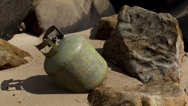 old cooking gas cylinder on sand beach photo