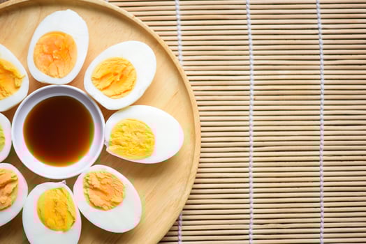 Eggs menu food boiled eggs in a wooden plate with fish sauce, cut in half egg yolks for cooking healthy eating eggs breakfast , top view photo