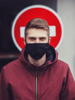 man in black mask in city photo