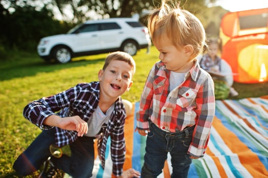 Kids spending time together. Outdoor picnic blanket. Brother and sister love. photo