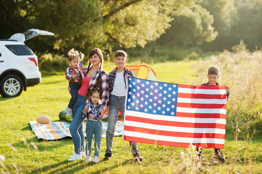 American family. Mother and four kids. With USA flags. America celebrating. photo