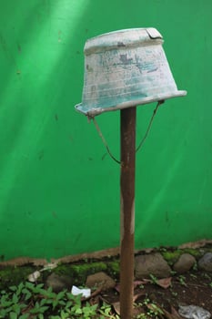 broken bucket placed on iron pipe photo