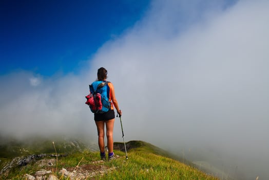 A girl looks afar in the fog at mountain valley during a walk photo