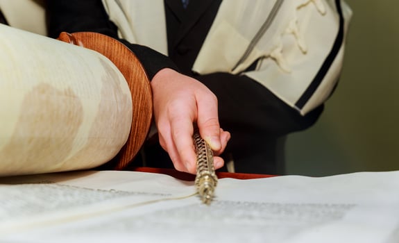 Hand of boy reading the Jewish Torah at Bar Mitzvah photo