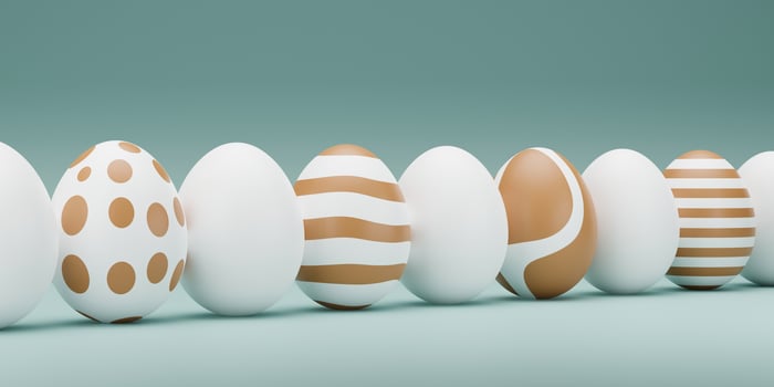 Row of funny easter eggs decorated with different colors and designs. 3D render illustration. Row of Happy Easter eggs in trendy colors on blue background, copy space. 3D rendering photo