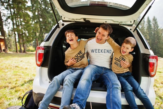 Family at vehicle interior. Father with his sons. Children in trunk. Traveling by car in the mountains, atmosphere concept. photo