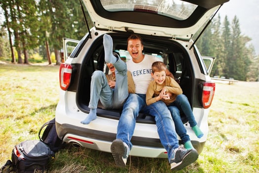 Family at vehicle interior. Father with his sons. Children in trunk. Traveling by car in the mountains, atmosphere concept. photo