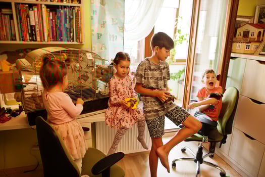 Four children holding their favorite pets on hands. Kids playing with hamster,turtle and parrots at home. photo