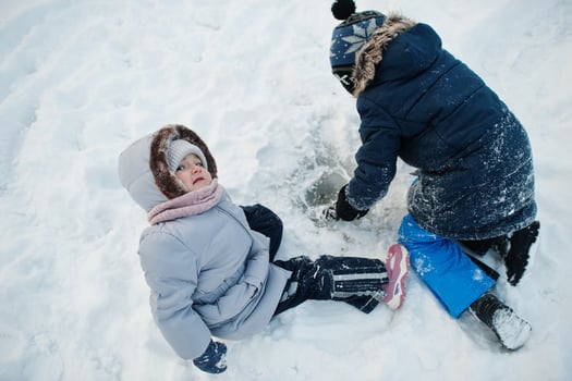 Boy with girl play in winter nature. Outdoors in snow. photo