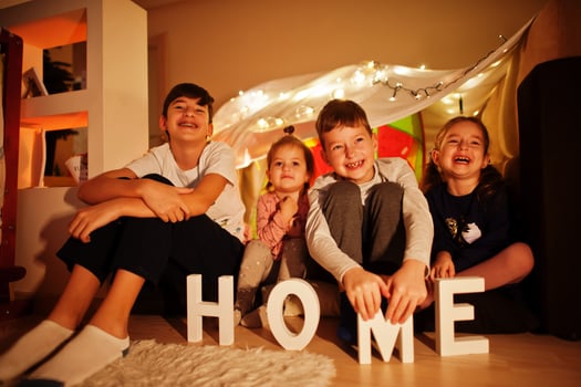 Kids in tent waching tv at night home. Hygge mood. photo