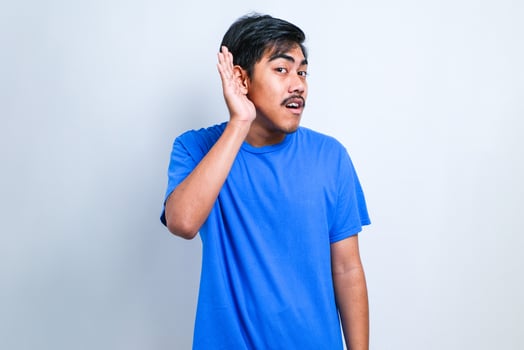Man smiling with hand over ear listening an hearing to rumor or gossip. Deafness concept. photo