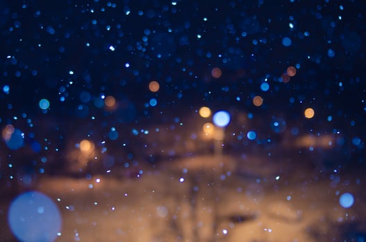 Nighttime falling snow with a bokeh effect against a background of city lights. photo