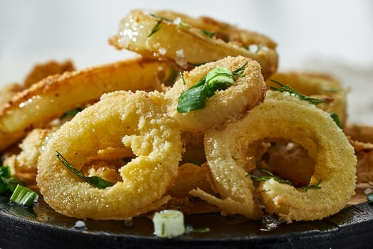 Golden Fried Onion Rings sprinkled with greenery close-up. photo
