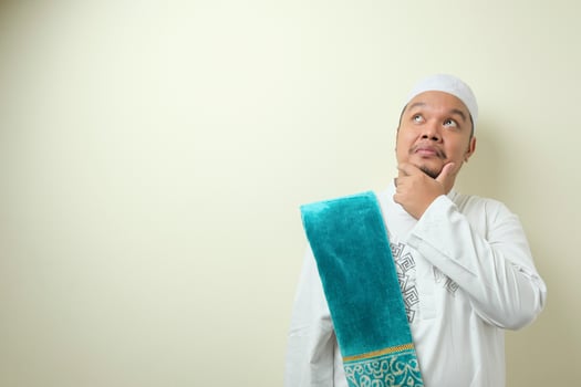 Portrait of young Asian muslim man having good idea photo