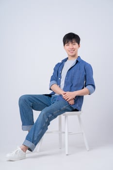 Young Asian man sitting on white background photo