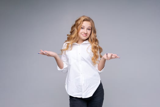 Young caucasian pretty charming blonde woman with wavy hair in white shirt photo