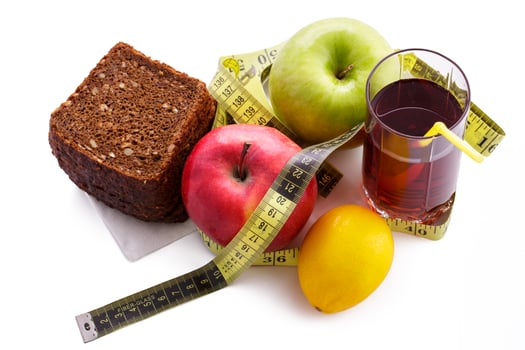 Rye bread apples and juice in  glass on a white background with a measuring tape photo