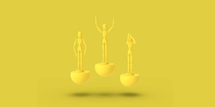 Three toy man of yellow color on a sports abstract pedestal. photo
