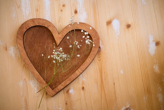 wooden heart lies on a wooden background photo