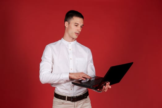 Portrait attractive focused cheerful brunette guy using laptop e-commerce photo