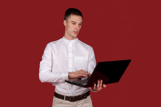 Holding laptop. Young Businessman using his laptop PC. Smiling handsome man photo
