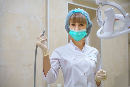 a female dentist holds a boron machine in her hand photo
