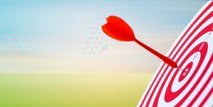 Close-up red dart arrow hitting in target center of dartboard sky background  Business goal or success goal marketing Strategy and business competition concept photo