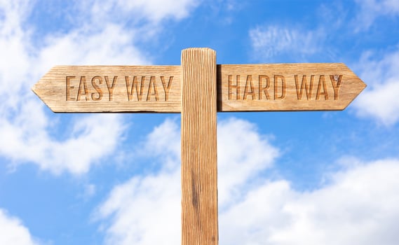 Easy way or hard way concept. Wooden signpost with message on sky background photo