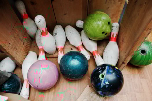 Crashed and damage bowling balls with pins at box photo