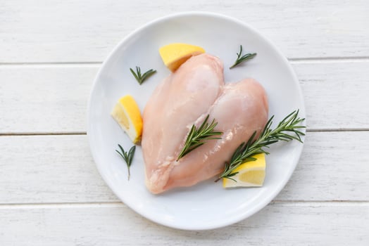raw chicken meat with rosemary and lemon fresh raw chicken breast heart shaped fillet on white plate photo