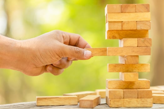 Hand holding blocks wood game on blurred green background. With copy space for text or design concept photo