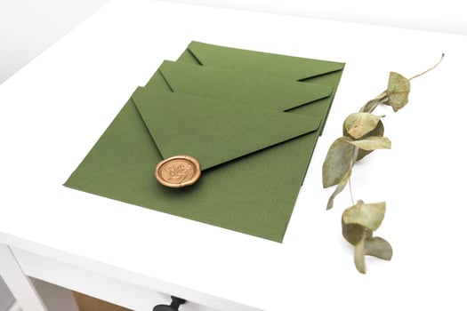 green envelope with designer cardboard and seal on a white background. Envelope with seal photo