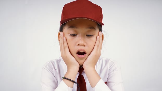 Elementary school asian girl who is surprised what she sees isolated on white background photo