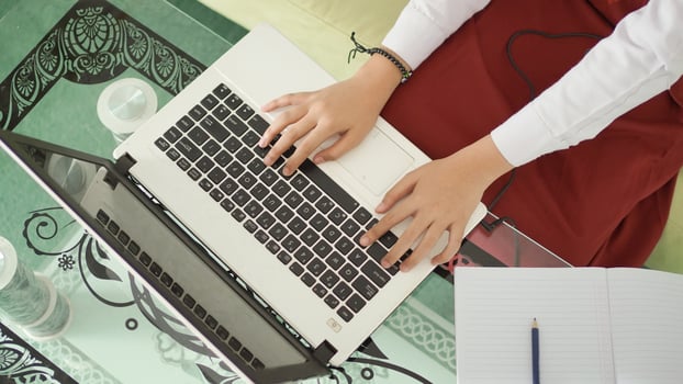 elementary school girl hand typing on laptop at home photo