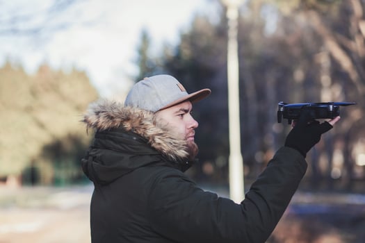 man holding a flying drone photo