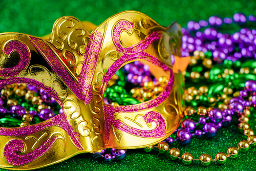 Carnival mask and colorful beads on green shiny background. Mardi Gras concept. Fat Tuesday symbol. photo