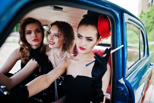 Three young girl in retro style dress seat on old classic vintage car. photo