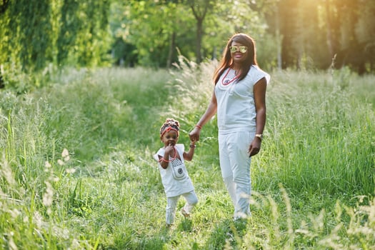 Black mother and daughter holding hand at park photo