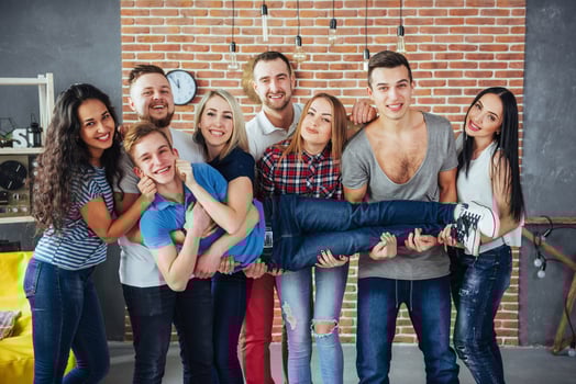 Group portrait of multi-ethnic boys and girls with colorful fashionable clothes holding friend posing on a brick wall, Urban style people having fun, Concepts about youth togetherness lifestyle photo