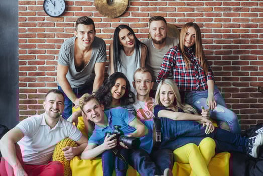 Group portrait of multi-ethnic boys and girls with colorful fashionable clothes holding friend posing on a brick wall, Urban style people having fun, Concepts about youth togetherness lifestyle photo