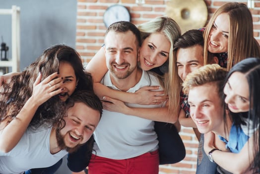 Group portrait of multi-ethnic boys and girls with colorful fashionable clothes holding friend  posing on a brick wall, Urban style people having fun, Concepts about youth  togetherness lifestyle photo