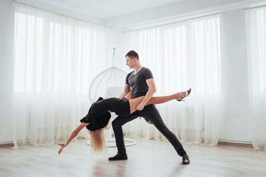 Young couple dancing latin music. Bachata, merengue, salsa. Two elegance pose on white room photo