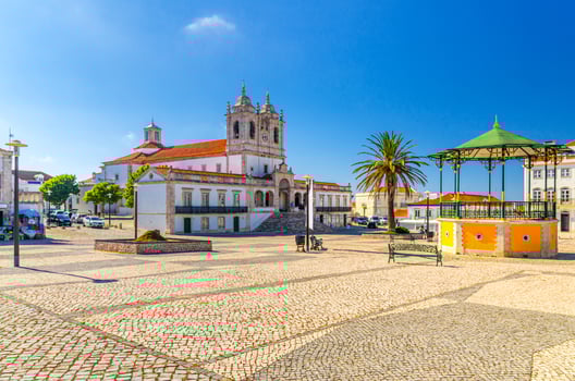 Sanctuary of Our Lady of Nazare catholic church in cobblestone square with palm trees in Sitio hilltop da Nazare town photo