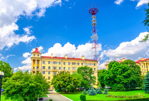 Television tower behind building in green trees park in Minsk city historical centre photo