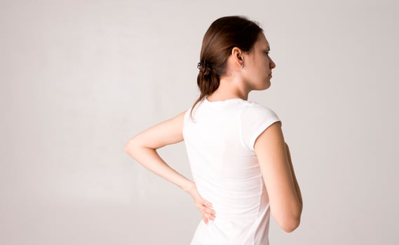 Attractive teenage girl suffers from backache. All on white background photo