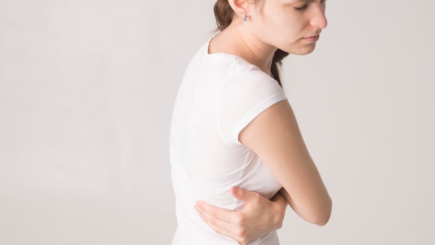 Attractive teenage girl suffers from backache. All on white background photo