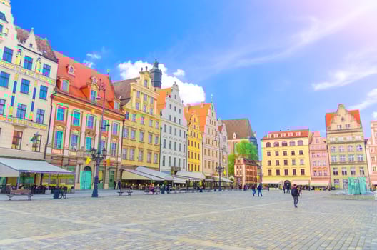Row of colorful traditional buildings with multicolored art facades and walking people on Rynek Market Square photo