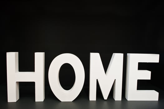 White wooden letters HOME at black background photo