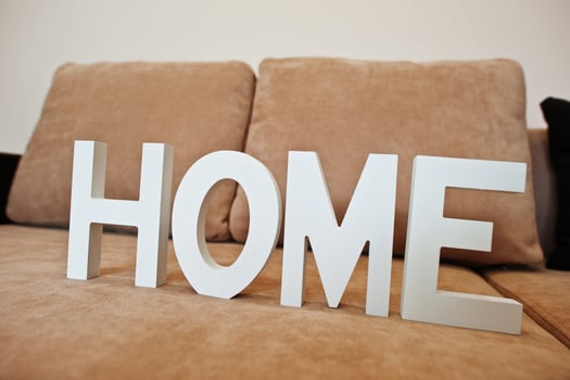 White wooden letters HOME at cofee corner sofa bed at light room photo