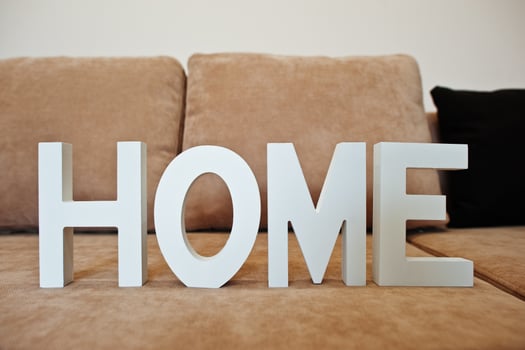 White wooden letters HOME at cofee corner sofa bed at light room photo